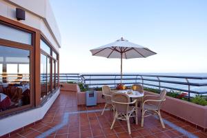 马贝拉普林塞萨海滩公寓酒店的庭院配有桌椅和遮阳伞。