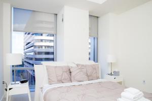 亚特兰大Atlanta Furnished Apartments - Great location in the Heart of the City的白色的卧室设有床和大窗户