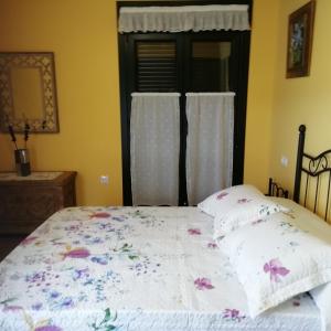 塔皮亚德卡萨列戈A Fragua的一间卧室配有一张带花卉棉被的床和窗户。