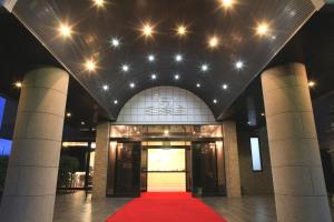 丰田市优哈池皇家酒店的灯火通明的建筑前的红地毯