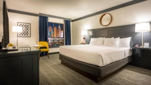 拉斯维加斯OYO Hotel and Casino Las Vegas的配有一张床、一张书桌和一扇窗户的酒店客房