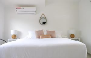 卡塔赫纳Mucura Hotel & Spa的白色卧室配有一张带枕头的大白色床