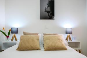 卡塔赫纳Mucura Hotel & Spa的卧室配有带两盏灯的白色床