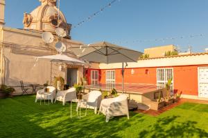 巴里斯帕拉诺豪华套房住宿加早餐旅馆的庭院配有白色的桌椅和遮阳伞。