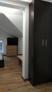 哈斯科沃Самостоятелен етаж от къща за гости的一间设有黑色衣柜和电视的客房