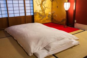 金泽金泽菊乃雅町屋的一间灯室里的一张白色床