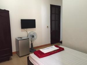 Quang TriKhách sạn nam đông的一间卧室配有一张床、一个风扇和一台电视。