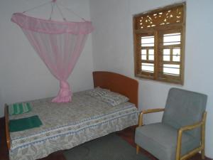 马纳尔El Shaddai的卧室配有床、椅子和窗户。