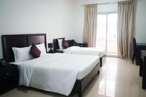 拉斯阿尔卡麦Aurak Guest House的酒店客房设有两张床和大窗户。