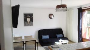欧特维尔－隆普内斯L'appart de lônes的客厅配有黑色沙发和桌子