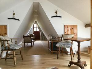 LlangathenDwynant - A Room with a View的客厅设有带椅子和桌子的阁楼
