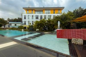 塔科拉迪Red Mango Hotel and Apartments的一座带游泳池和喷泉的建筑