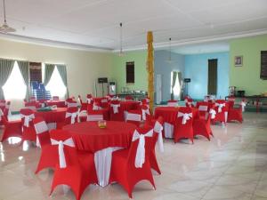 英德GLOBAL VIEW HOTEL的大房间设有红色和白色的桌椅
