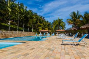 纳扎雷保利斯塔加利西亚庄园别墅酒店的度假村的游泳池,配有椅子和棕榈树