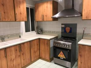 吉达Ajwaa Suites的厨房配有木制橱柜和炉灶烤箱。