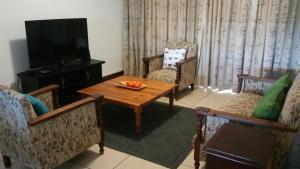 莫塞尔湾Vista Bonita Apartments的客厅配有桌椅和电视。