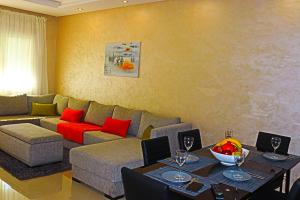 拉巴特Appartement Standing Quartier Tour Hassane (près Marina)的客厅配有沙发和带红色枕头的桌子