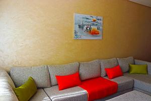 拉巴特Appartement Standing Quartier Tour Hassane (près Marina)的客厅配有红色和绿色枕头的沙发