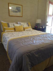 ChlorideGrand Canyon West Hotel Sheps Miners Inn的一间卧室配有一张大床,提供黄色和灰色的枕头