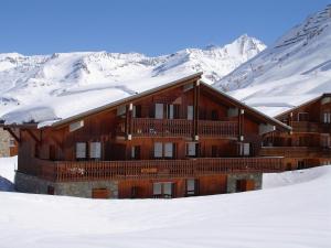 蒂涅Chalet Le Grand Cap的雪覆盖着雪地的山林小屋