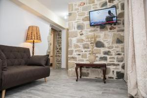 皮特斯迪亚Chalkidιό的客厅配有沙发和石墙电视。