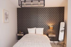 昂热Le Pompidou T2 pour 2 à 4 pers avec parking privé & balcon Place Ney的一间卧室配有一张带墙壁的床