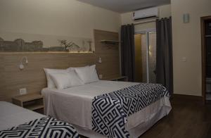 阿拉沙Pousada Araxá的酒店客房设有两张床和窗户。