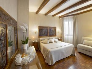 威尼斯坎皮耶罗酒店的卧室配有白色的床和沙发