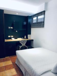 台南来七桃旅店的一间卧室配有一张床和一张桌子及椅子
