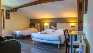 昂代贝尔维酒店的酒店客房设有两张床和一张桌子。