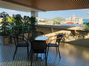 普吉镇Peranakan Boutique Hotel - SHA Plus的阳台配有桌椅,享有美景。