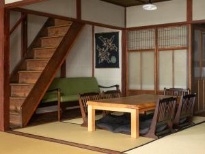 京都京町家度假屋雁音的一间带桌子和楼梯的用餐室