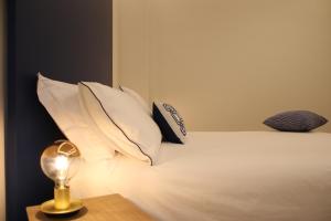 那不勒斯La Casa nel Parco的一张带枕头的床和一张桌子上的台灯