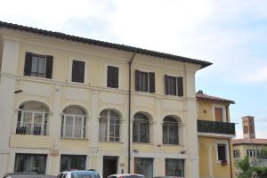列蒂Casa Sigiu - Il Fiume的一座黄色的建筑,有窗户,汽车停在建筑前面