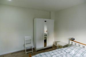 埃森Ferienwohnung Essen - Zentral im Ruhrgebiet的卧室配有白色橱柜和椅子