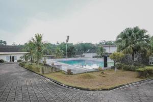 占碑市RedDoorz Premium @ Jalan Pal 10 Jambi的一座楼前棕榈树游泳池