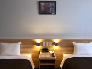 泉佐野泉佐野中心关西国际机场酒店的酒店客房设有两张床和一张桌子上的电话