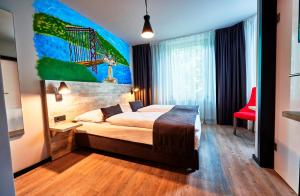 汉堡Urban Home Hotel的卧室配有一张床,墙上挂有绘画作品