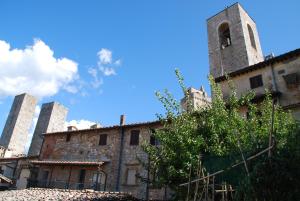 圣吉米纳诺Orto di Emma的一座带塔楼和教堂的古老建筑