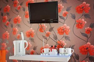 布莱克浦托贝莫里酒店的架子上放有杯子和杯子的电视机