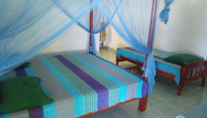 汉班托塔Lagoon Inn的一间卧室配有两张床和蓝色窗帘