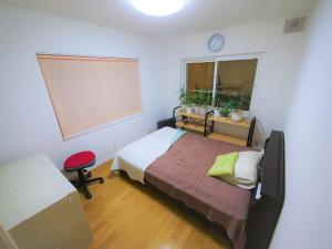 札幌Minpaku Mon的一间卧室设有一张床和一个大窗户