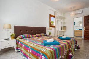 普拉亚布兰卡克利托别墅的一间卧室配有一张带蓝色枕头的大床