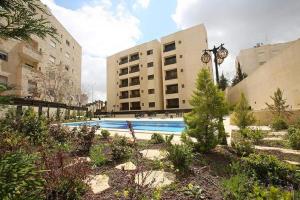 安曼Dair Ghbar Apartment的一座建筑物中央的游泳池