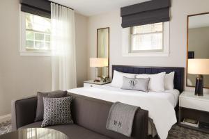 波士顿The Whitney Hotel Boston的卧室配有一张白色大床和一把椅子