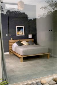 卡维塔Lilan Nature, Modern House N°2, private swimming pool的一间卧室设有一张床和玻璃墙
