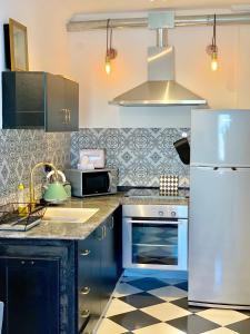 内坦亚Shantell Luxury Apartment的厨房配有蓝色橱柜和白色冰箱