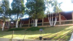 伊比乌纳Linda Chacara em IBIUNA的一座有树木的院子和一座建筑