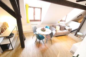 科尔马Colmar City Center - Appartement PETIT OURS - BookingAlsace的客厅配有桌椅和沙发