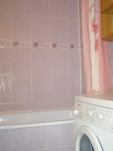 罗夫诺Comfortable apartments in centre with 3 bedrooms的粉红色瓷砖浴室内的洗衣机